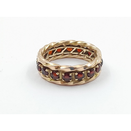 52 - A vintage, 9 K yellow gold, full eternity ring with garnets. Ring size: M, weight: 5.27 g. In a pres... 