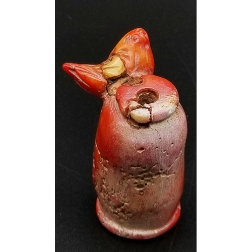 101 - An antique, Chinese, red coral, snuff bottle, with carved bird on side. Top missing. Dimensions: 6.5... 