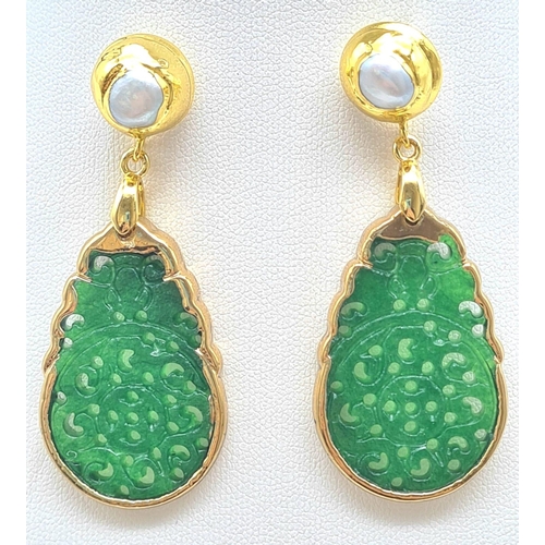 133 - An intricately carved green jade pair of earrings with genuine pearls. Length: 6 cm. Presented in a ... 