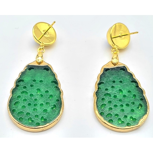 133 - An intricately carved green jade pair of earrings with genuine pearls. Length: 6 cm. Presented in a ... 