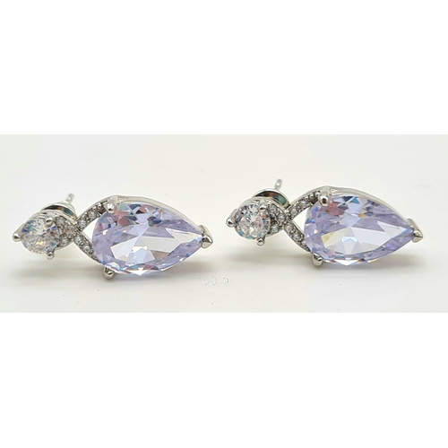 161 - A sterling silver ring with a large tear drop cubic zirconium and matching earrings. Presented in a ... 