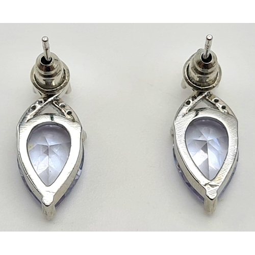 161 - A sterling silver ring with a large tear drop cubic zirconium and matching earrings. Presented in a ... 