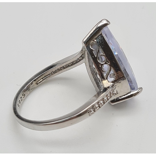 161 - A sterling silver ring with a large tear drop cubic zirconium and matching earrings. Presented in a ... 