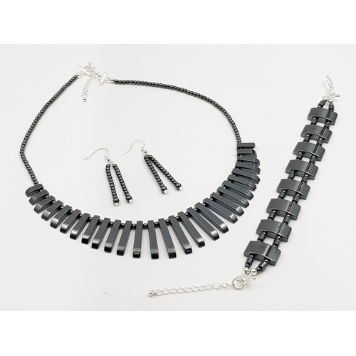 231 - A beautiful, modern necklace, bracelet and earrings set made of highly polished haematite. In a pres... 