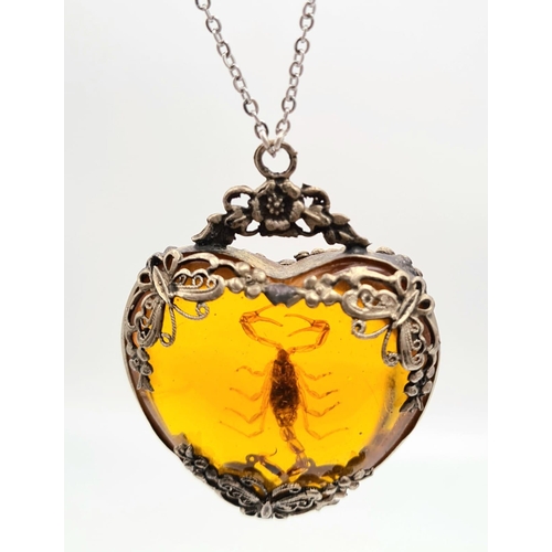 238 - A vintage, heart shaped, amber pendant with a small scorpion inclusion, on a sterling silver chain. ... 