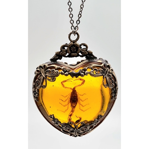 238 - A vintage, heart shaped, amber pendant with a small scorpion inclusion, on a sterling silver chain. ... 