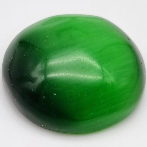 126 - A fascinating, large (208 CARATS), green, cat’s eye round cabochon. No scratches, cracks or other is... 