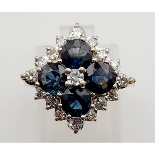 453 - An 18K Yellow Gold Diamond and Sapphire Ring. Four clean blue sapphires surrounded by a cluster of d... 