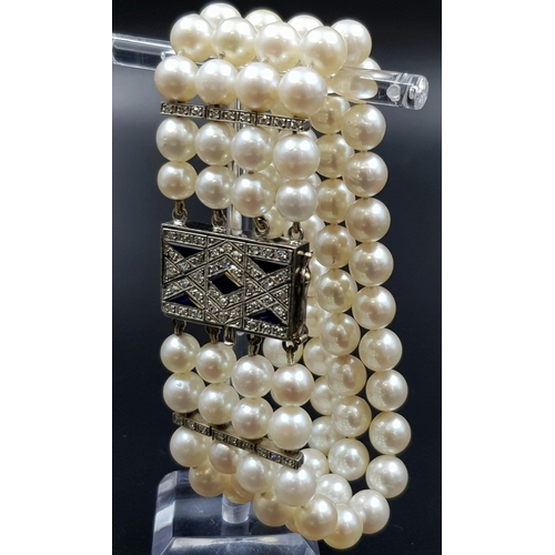 482 - A 4 ROW AKOYA PEARL BRACELET WITH ART DECO STYLE 14K GOLD DIAMOND AND SAPPHIRE CLASP. 67.3gms