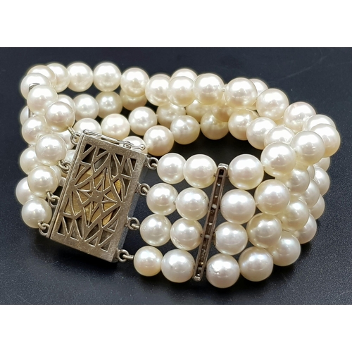 482 - A 4 ROW AKOYA PEARL BRACELET WITH ART DECO STYLE 14K GOLD DIAMOND AND SAPPHIRE CLASP. 67.3gms