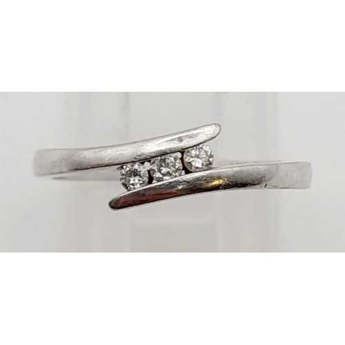 511 - A Platinum Three Diamond Twist Ring. 0.10ct. Size M. 2.9g