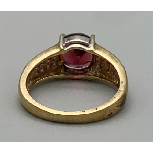 559 - A 9K Yellow Gold Fancy Pink and Red Stone Ring. Size J 1/2. 3g.