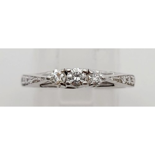 587 - A 9K White Gold Three Diamond Stone Ring. Size M.
1.9g. Plus smaller diamonds on shoulders.