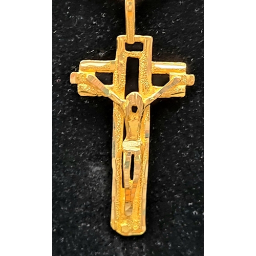 131 - An 18 K yellow gold cross and chain. Chain length: 73 cm, total weight: 11.56 g.