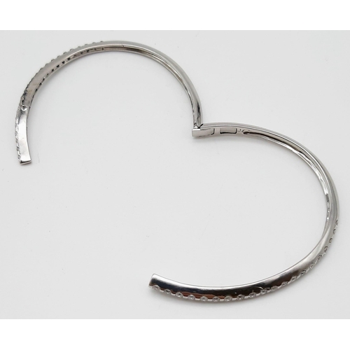 443 - A 14K WHITE GOLD AND DIAMOND BANGLE IN STUNNING CROSS-OVER MODERN DESIGN WITH 2CT DIAMONDS . 16.2gms