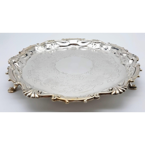 485 - A HALLMARKED SILVER FOOTED PLATTER DATED 1745 WITH SHELL AND SCROLL EDGING. 452gms   24cms diameter