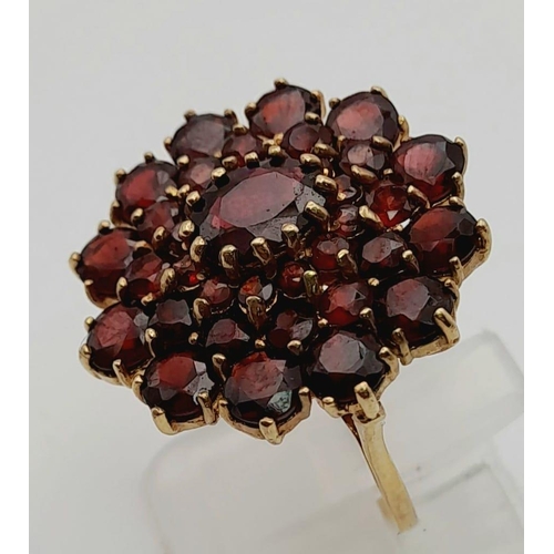 122 - 9K Yellow Gold Garnet set Cluster Ring. Size L 7.1g