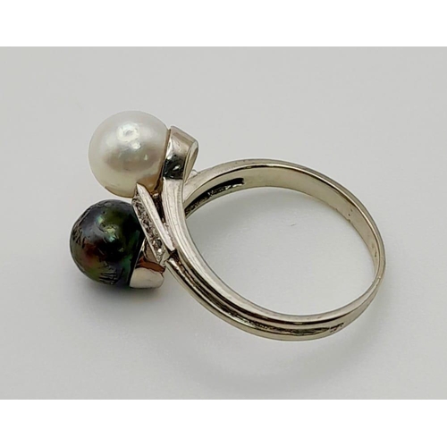 142 - An 18 K white gold ring with two Tahitian pearls (one black, one white) and diamonds on the shoulder... 