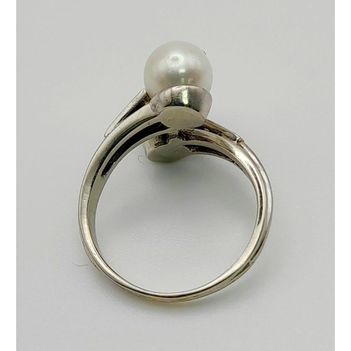 142 - An 18 K white gold ring with two Tahitian pearls (one black, one white) and diamonds on the shoulder... 