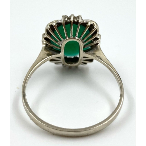 225 - A LARGE VINTAGE EMERALD RING SET IN 18K WHITE GOLD WITH A DIAMOND HALO. 3.5gms   size U