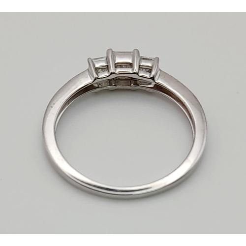 88 - An 18 K white gold ring with a trilogy of square diamonds. Ring size: N, weight: 2.43 g.