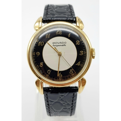 14 - 14K YELLOW GOLD MOVADO WATCH, CIRCULAR FACE GOLD DIAL 32MM, MANUAL WIND AND BLACK STRAP