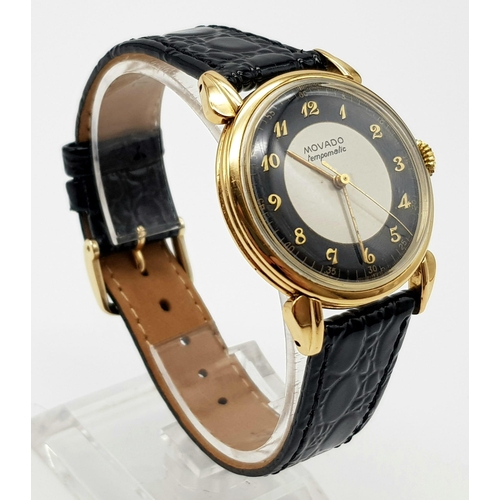 14 - 14K YELLOW GOLD MOVADO WATCH, CIRCULAR FACE GOLD DIAL 32MM, MANUAL WIND AND BLACK STRAP