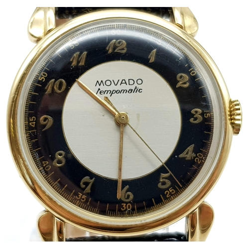 14 - 14K YELLOW GOLD MOVADO WATCH, CIRCULAR FACE GOLD DIAL 32MM, MANUAL WIND AND BLACK STRAP