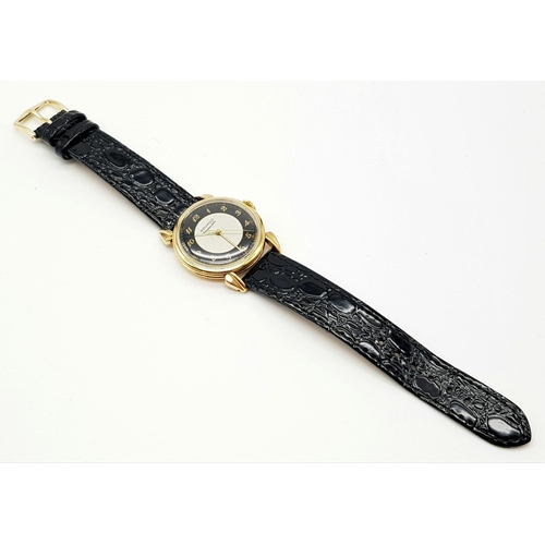 14 - 14K YELLOW GOLD MOVADO WATCH, CIRCULAR FACE GOLD DIAL 32MM, MANUAL WIND AND BLACK STRAP