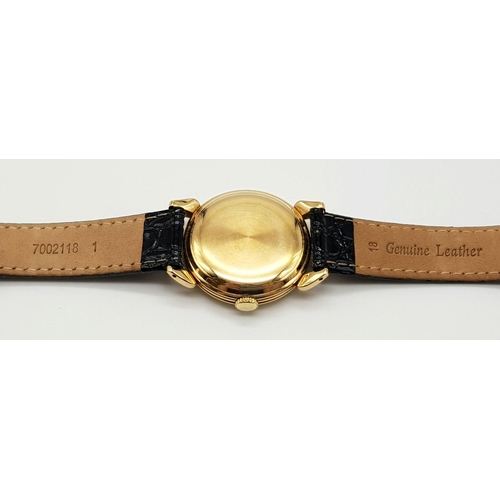 14 - 14K YELLOW GOLD MOVADO WATCH, CIRCULAR FACE GOLD DIAL 32MM, MANUAL WIND AND BLACK STRAP