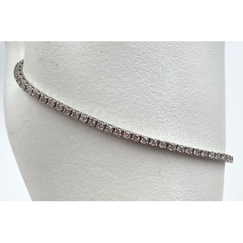 473 - AN 18K WHITE GOLD AND 3CT DIAMOND TENNIS BRACELET.  7.4gms