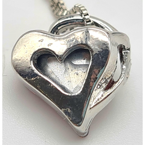 578 - A PRETTY MODERN HEART SHAPED PENDANT ON A 40cms silver chain.