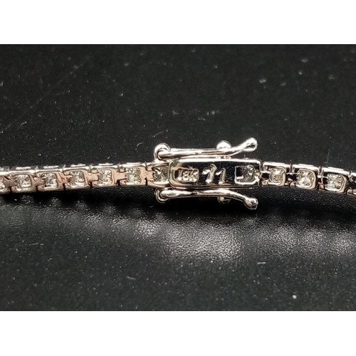 473 - AN 18K WHITE GOLD AND 3CT DIAMOND TENNIS BRACELET.  7.4gms