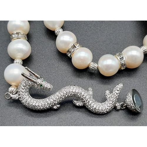 127 - A high quality, Chinese, large pearl necklace with a dragon clasp accompanied by matching earrings. ... 