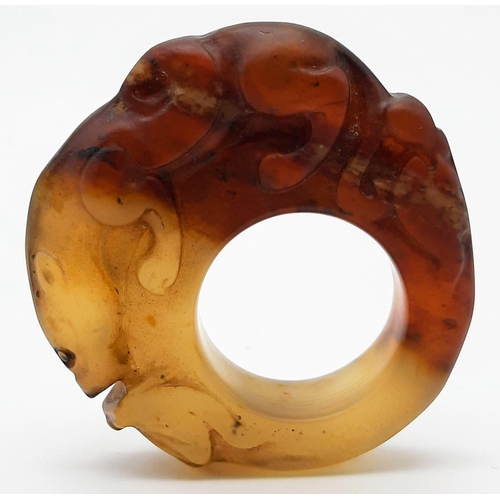 148 - A Chinese, Archaic style, two tone jade ring, hand carved with a mythical beast and a frog. Dimensio... 