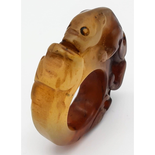 148 - A Chinese, Archaic style, two tone jade ring, hand carved with a mythical beast and a frog. Dimensio... 