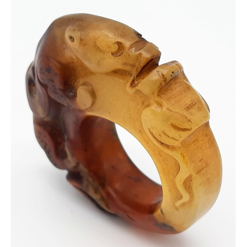 148 - A Chinese, Archaic style, two tone jade ring, hand carved with a mythical beast and a frog. Dimensio... 