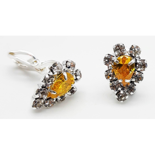 176 - A white metal ring and earrings set with yellow topaz and white sapphires. Ring size: N, presented i... 