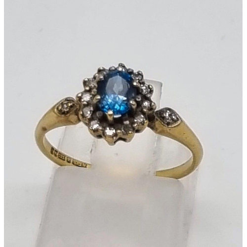 53 - A 9K Yellow Gold Topaz and Diamond Ring. Centre blue topaz surrounded by a halo of diamonds. Size L.... 