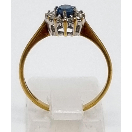 509 - A 9K Yellow Gold Topaz and Diamond Ring. Centre blue topaz surrounded by a halo of diamonds. Size L.... 