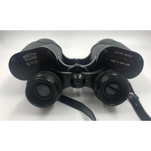 1070 - 2 x pairs of BINOCULARS. A pair of Prinz, 10 x 50 coated optics with case and a smaller pair of
Hali... 