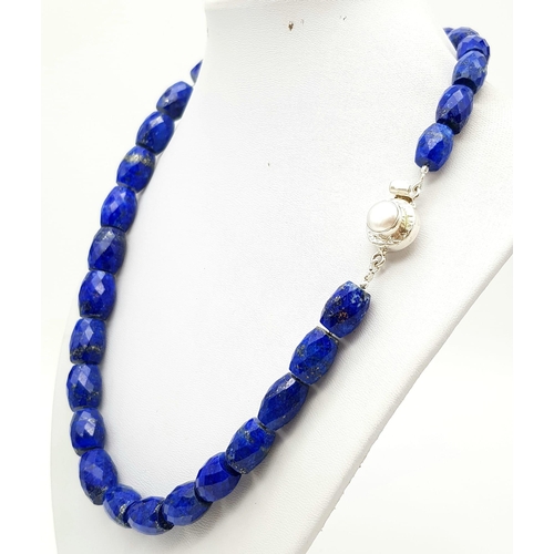 634 - A 495ct Fancy Lapis Lazuli Drum Shape bead necklace with a Pearl clasp in 925 silver. 44cm.