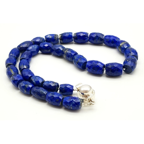 634 - A 495ct Fancy Lapis Lazuli Drum Shape bead necklace with a Pearl clasp in 925 silver. 44cm.