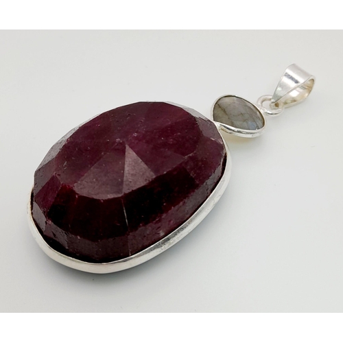 718 - A 285ct Oval Shape Ruby Gemstone Pendant set in 925 Silver. 5cm. Comes with a disappearing silver ne... 