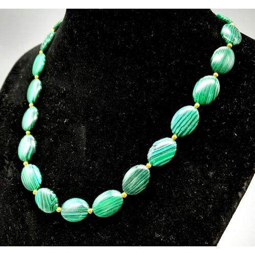 1090 - A Green Malachite Oval Bead Necklace with Gilded Spacers and Clasp. 44cm