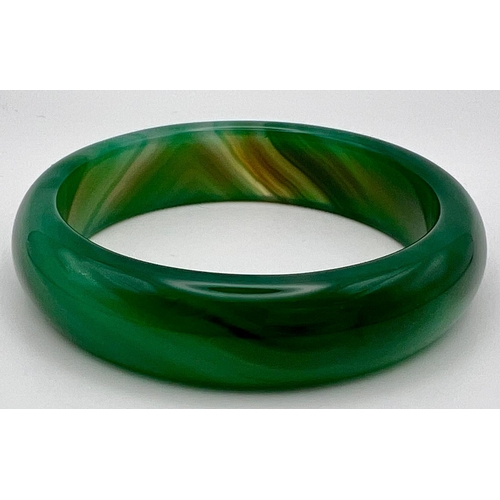 1125 - A Green and White Jade Bangle. 6cm inner diameter.