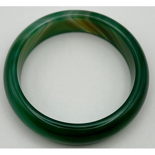 1125 - A Green and White Jade Bangle. 6cm inner diameter.