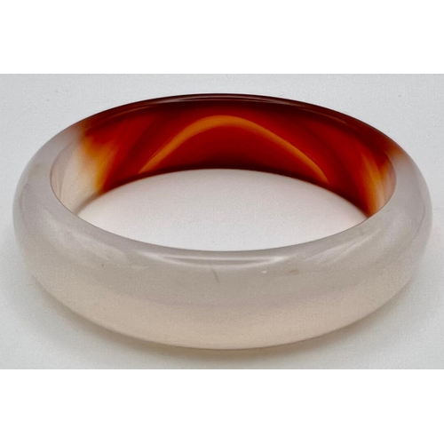 762 - A White and Red Jade Bangle. 6cm inner diameter,