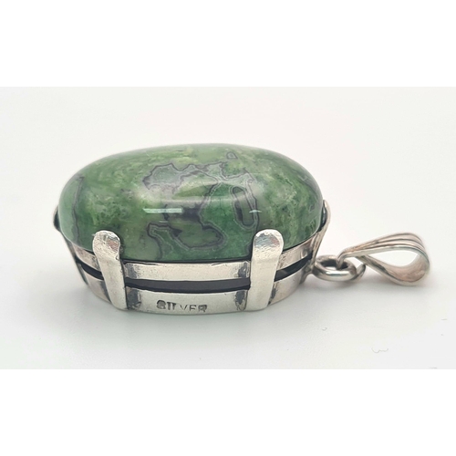 834 - A Mottled Jade Pendent set in Silver. 3cm