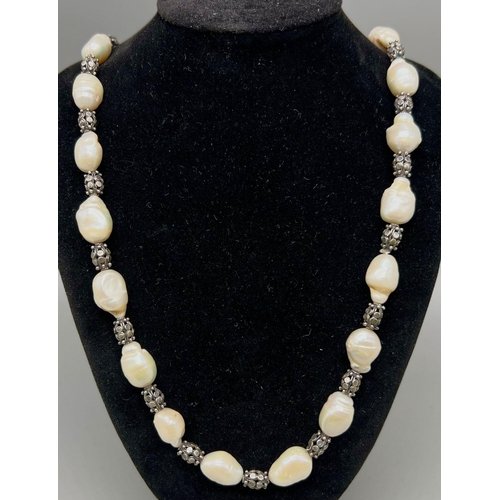 906 - A Vintage Baroque Pearl Necklace with Geometric Patterned Barrel Spacers. 68cm. 100g total weight.